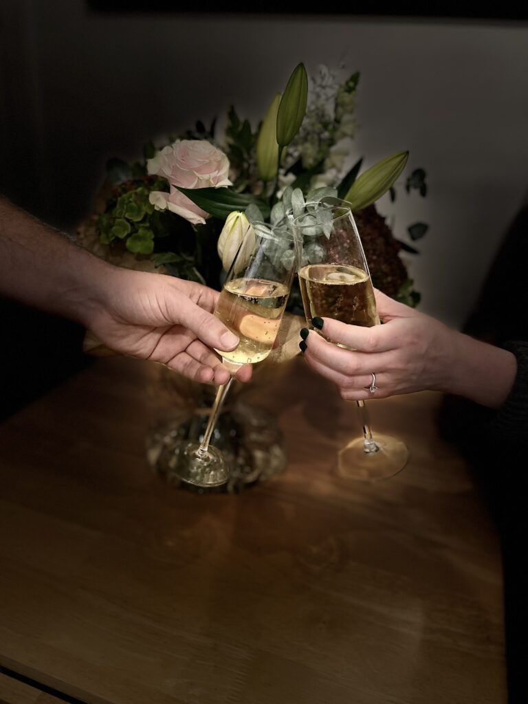 Celebrant Services | Two hands holding champagne glasses.